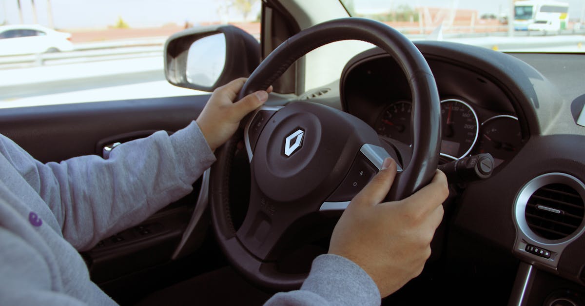 Close-up of hands on steering wheel while driving through Mexico in daylight.
